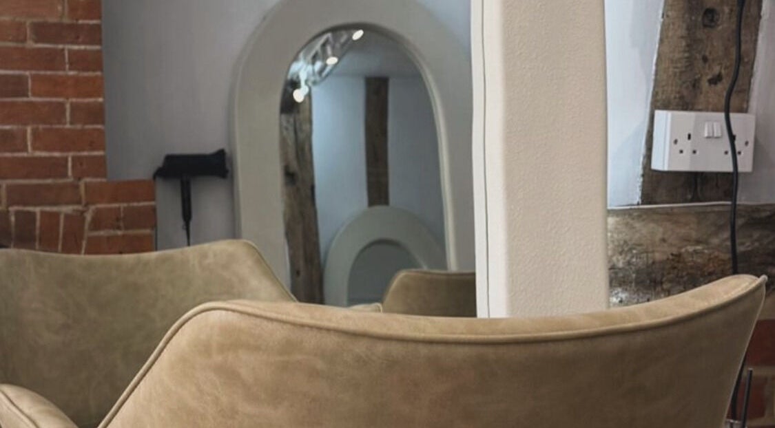 Modern salon interior with mirrors and cozy seating at Leigh-Anne Hairdressing, Woodbridge, England, GB.