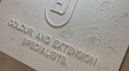 Close-up of a textured signage for Leigh-Anne Hairdressing, Woodbridge, England, GB, specializing in color and extensions.