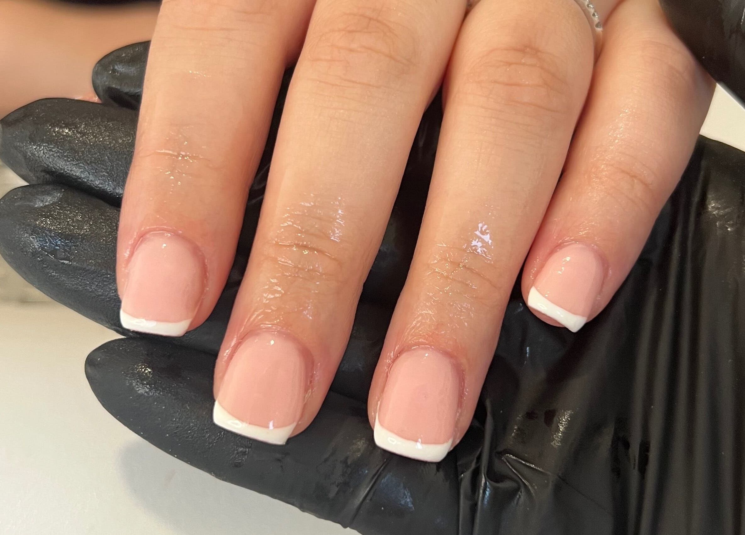 Elegant French manicure at DLBeauty in Branston, England, GB, showcasing glossy, perfectly polished nails.