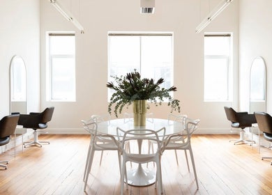 Bright interior of Tudoi Hair Studio in Melbourne, Victoria, AU with chic chairs and a stylish table centerpiece.