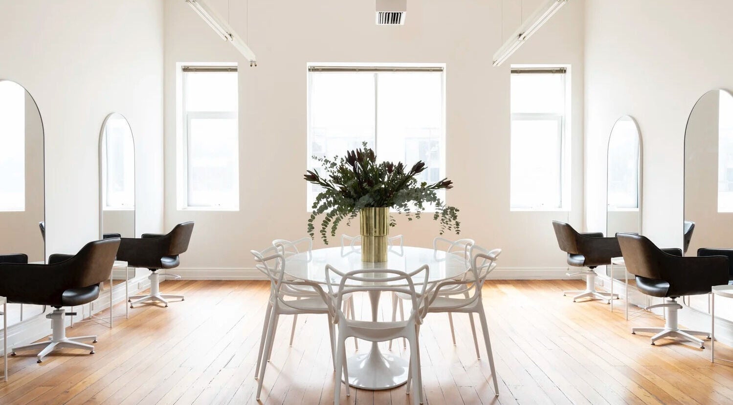 Bright interior of Tudoi Hair Studio in Melbourne, Victoria, AU with chic chairs and a stylish table centerpiece.