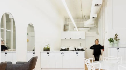 Bright, minimalist interior of Tudoi Hair Studio in Melbourne, Victoria, AU with modern seating and decor.
