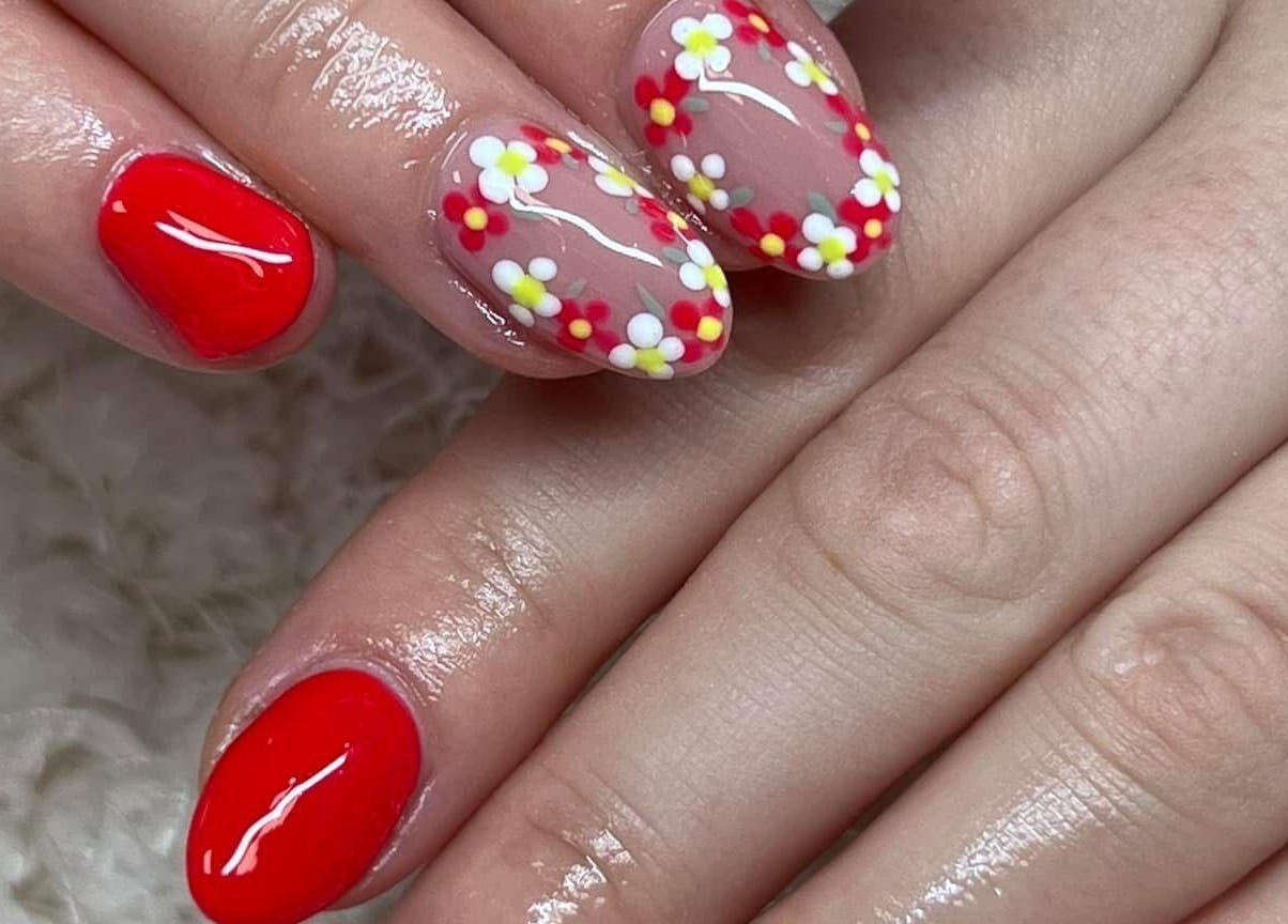 Beautiful floral nail art at The Beauty Office, Nuneaton, England, GB, showcasing glossy red and flower designs.