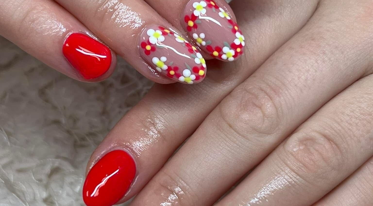 Beautiful floral nail art at The Beauty Office, Nuneaton, England, GB, showcasing glossy red and flower designs.