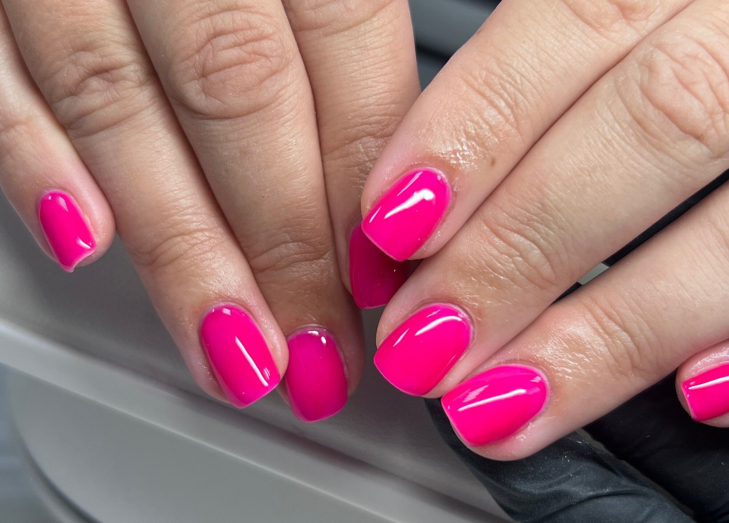 Bright pink manicured nails at The Beauty Office, Nuneaton, England, GB.