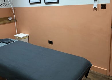 A serene massage room at Alex Massage Therapies, Bristol, England, GB, featuring a neatly made bed and calming decor.