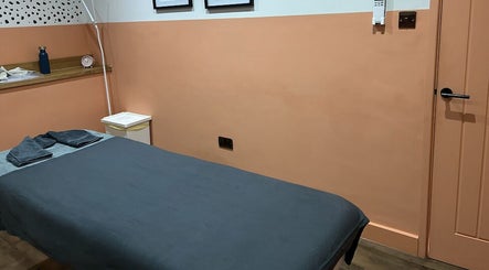 A serene massage room at Alex Massage Therapies, Bristol, England, GB, featuring a neatly made bed and calming decor.
