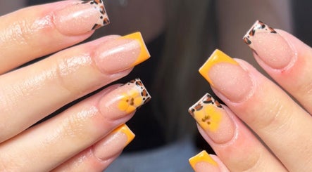 Stylish leopard-patterned acrylic nails with yellow floral tips at JW Beauty, Tyldesley, England, GB.
