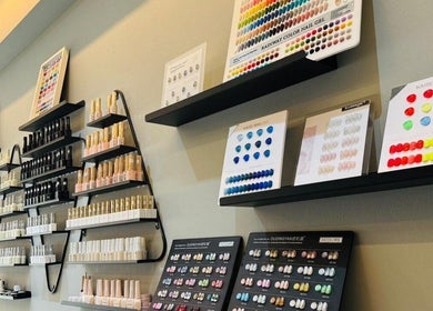 Nail Lounge in Singapore, SG displays a vibrant wall of nail polishes and color samples.