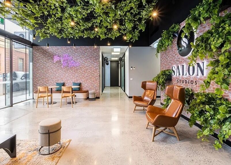 Spacious, modern interior of KC Hair / Kelvin of Canterbury in Melbourne, Victoria, AU with lush greenery and seating.