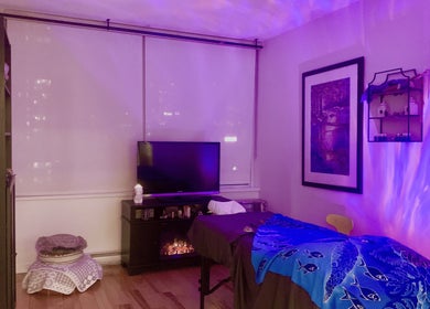 Tranquil massage room at Tension Release Studio, Vancouver, British Columbia, CA with calming purple lighting.