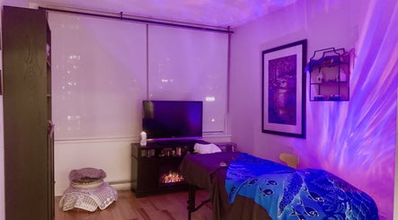 Relaxing massage room at Tension Release Studio in Vancouver, BC featuring ambient lighting and calming decor.