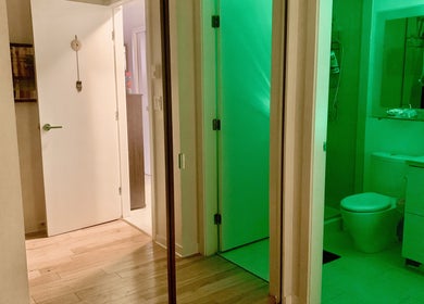Interior hall with green-lit bathroom at Tension Release Studio, Vancouver, British Columbia, CA.
