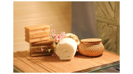 Spa essentials at Tension Release Studio, Vancouver, BC, CA: massage bars, rolled towel, flowers, and wicker jar.