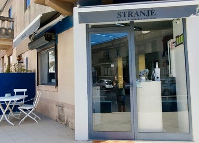 Front view of Stranjé Hairdressing in Ħ'attard, MT, featuring elegant storefront and outdoor seating.