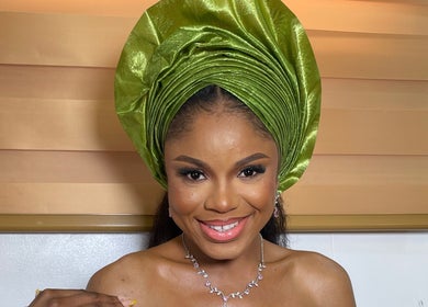 Smiling woman in elegant green headwrap at Pwencex Empire, Kingswinford, England, GB.