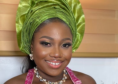 Smiling woman in green headwrap at Pwencex Empire, Kingswinford, England, GB.
