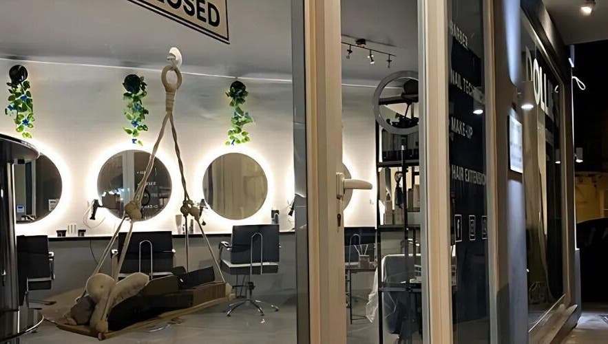 Chic interior of Dollie's Hair Lounge in Rabat, MT, featuring stylish mirrors and lush greenery.