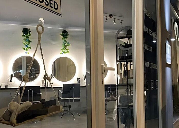 Chic interior of Dollie's Hair Lounge in Rabat, MT, featuring stylish mirrors and lush greenery.