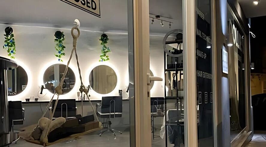 Chic interior of Dollie's Hair Lounge in Rabat, MT, featuring stylish mirrors and lush greenery.