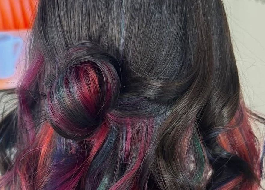 Elegant multi-colored hairstyle at Dollie's Hair Lounge in Rabat, MT showcasing vibrant highlights.