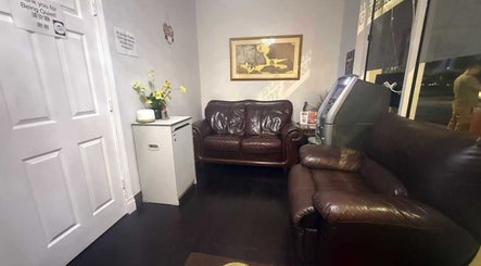 Inviting waiting area at Chi Foot Spa, Pembroke Pines, Florida, US, with brown leather sofas and calming decor.