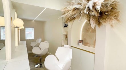 Luxurious beauty salon interior at By Élize, Plymouth, England, GB with plush white chairs and modern decor.