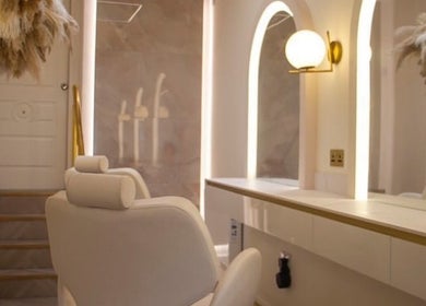 Elegant beauty salon interior at By Élize, Plymouth, England, GB featuring plush chair and illuminated mirrors.