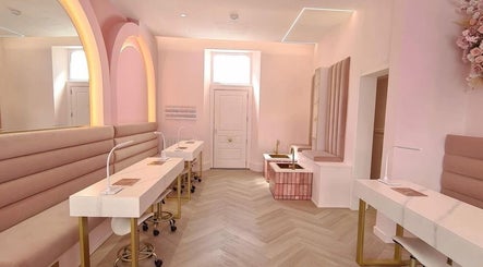 Chic beauty salon interior at By Élize in Plymouth, England, GB with pastel pink decor and manicure stations.