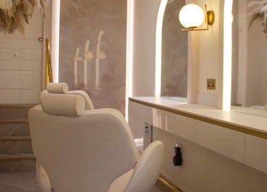 Chic salon interior at By Élize in Plymouth, England, GB with plush seating and ambient lighting.