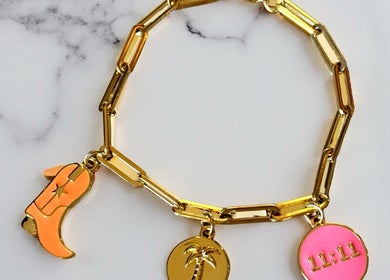 Gold charm bracelet from Tiger Bling in Edinburgh, Scotland, GB on marble surface.