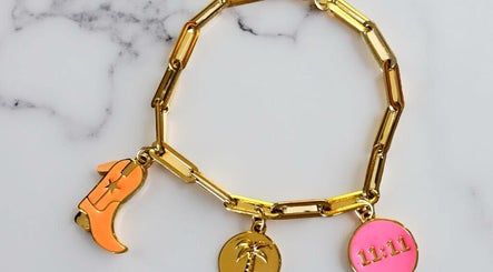 Gold charm bracelet from Tiger Bling in Edinburgh, Scotland, GB on marble surface.