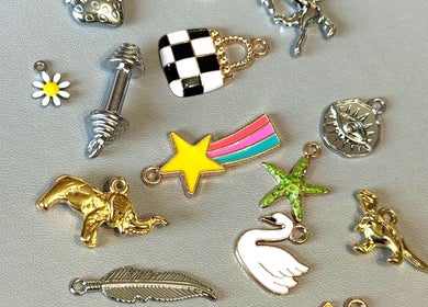 Assorted charms at Tiger Bling, Edinburgh, Scotland, GB. Features star, elephant, swan designs on display.