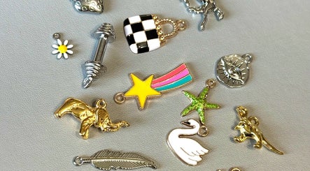 Assorted charms at Tiger Bling, Edinburgh, Scotland, GB. Features star, elephant, swan designs on display.