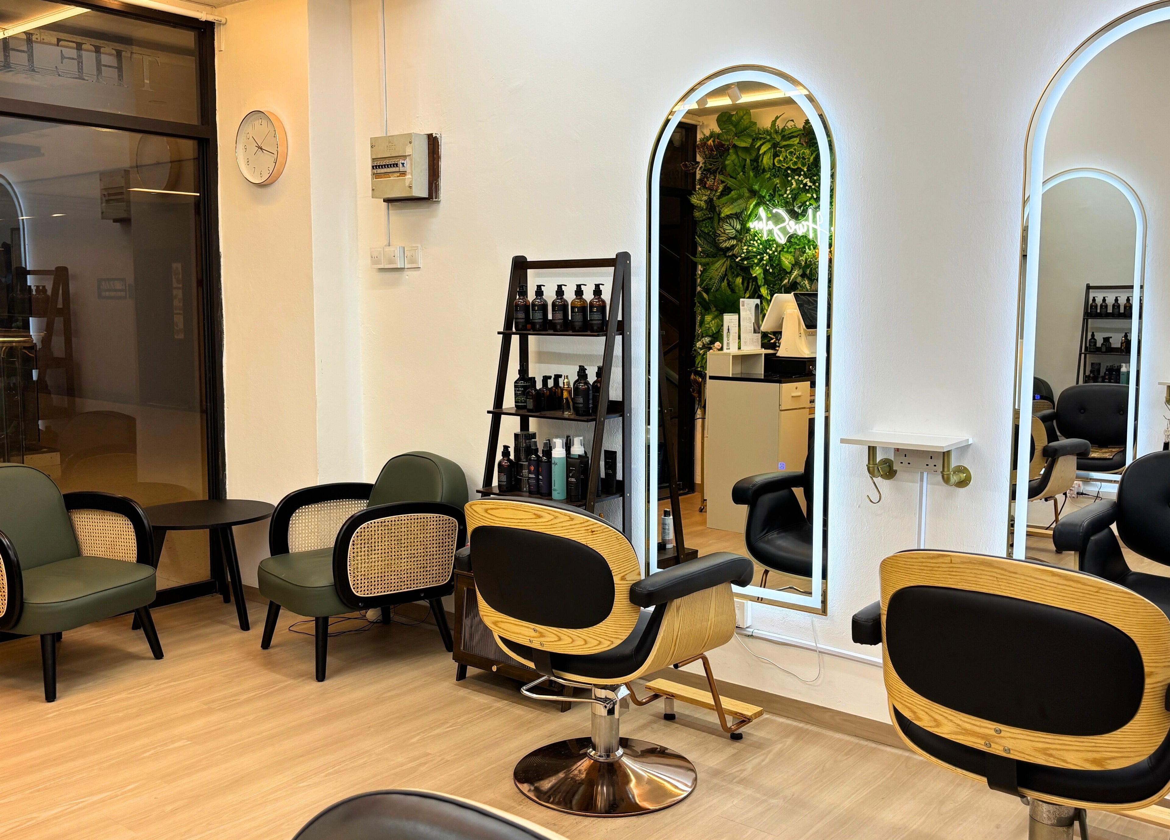 Modern interior of The Hive Salon, Singapore, SG, featuring stylish chairs and mirrors with sleek decor.