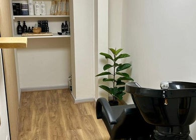 Wash station at Kindred Hair & Beauty, Brighton And Hove, England, GB, showcasing sleek design and product shelves.