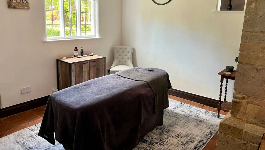 Relaxing treatment room at The Serenity Lodge, Long Marston, England, GB, with a massage table and calming decor.