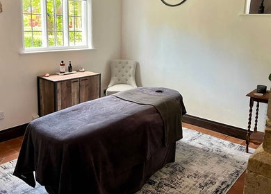 Relaxing treatment room at The Serenity Lodge, Long Marston, England, GB, with a massage table and calming decor.