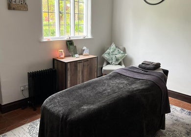 Cozy massage room at The Serenity Lodge, Long Marston, England, GB with soft lighting and comfortable decor.