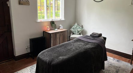 Cozy massage room at The Serenity Lodge, Long Marston, England, GB with soft lighting and comfortable decor.