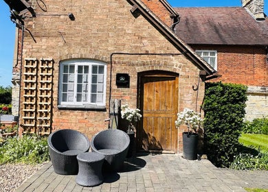 Cozy brick entrance at The Serenity Lodge, Long Marston, England with inviting patio seating.