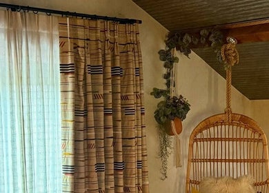 Relaxing corner with woven chair at The Sanctuary at Upper Farm, Tiffield, England, GB.