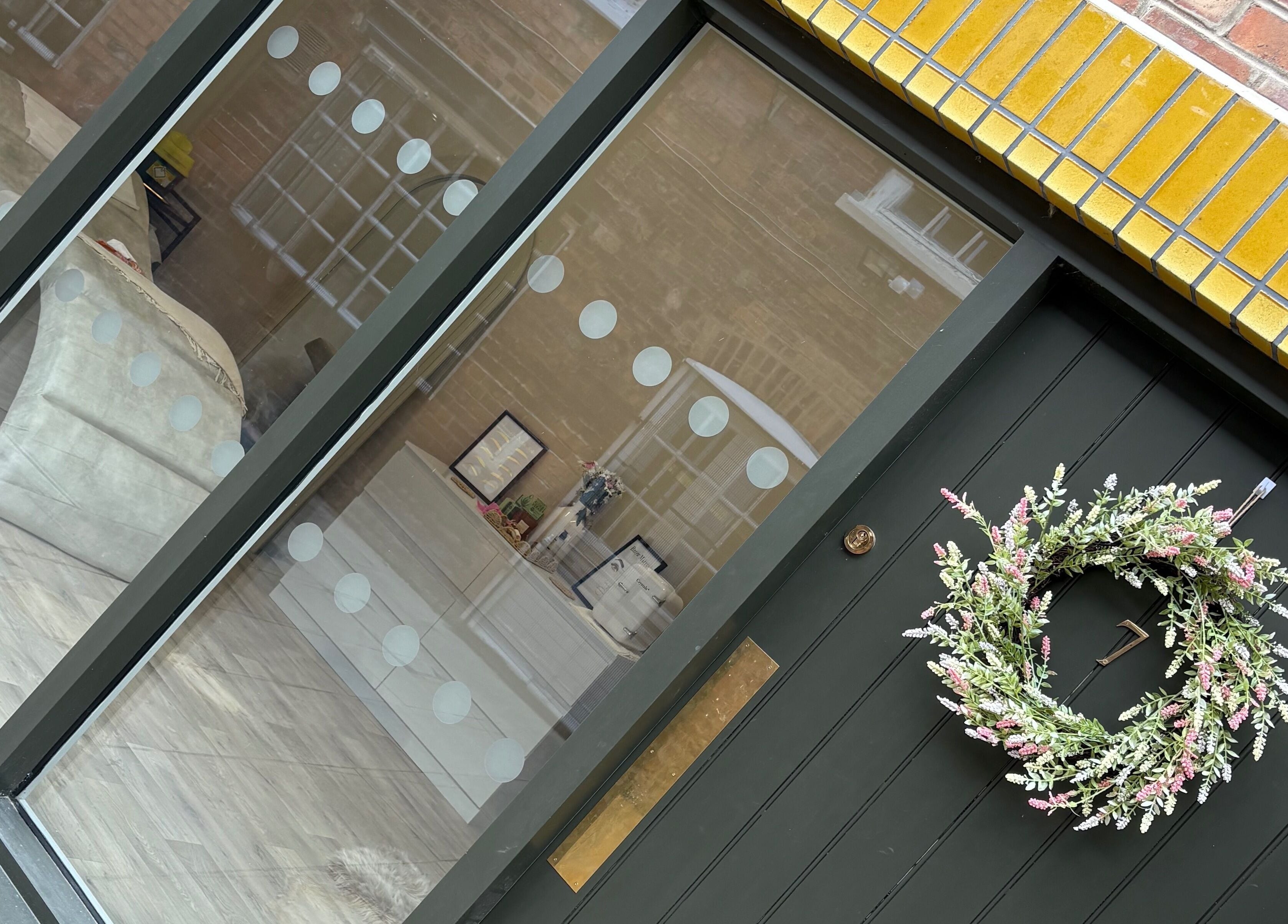 Entrance of keishalilly aesthetics in Gainsborough, England showcasing modern decor and a floral wreath.