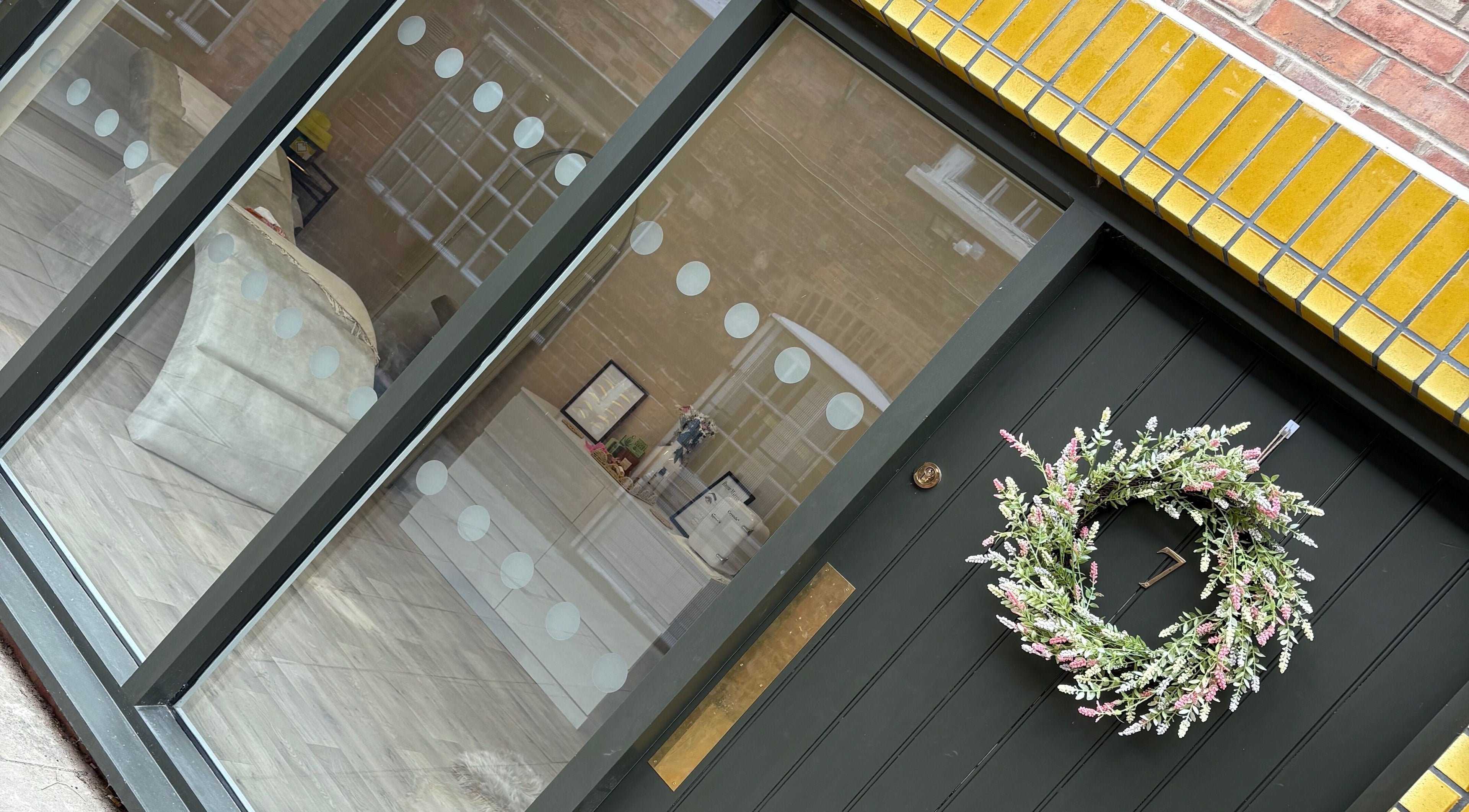 Entrance of keishalilly aesthetics in Gainsborough, England showcasing modern decor and a floral wreath.