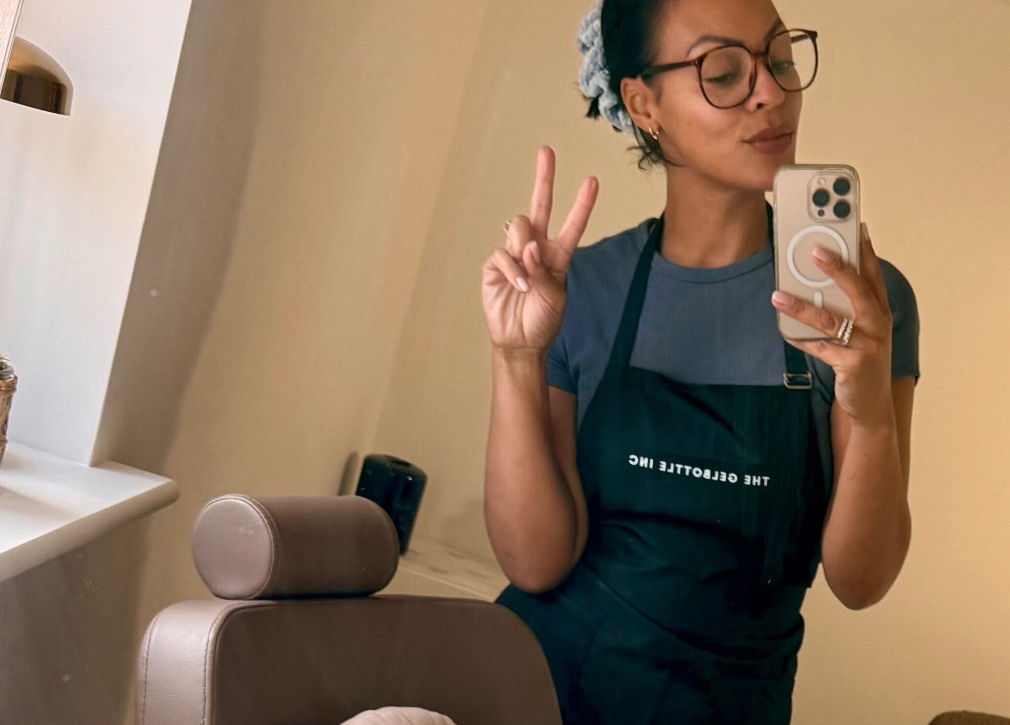 A stylist at By Carmen Rosa in Broughton Astley, England, GB, taking a mirror selfie while holding a peace sign.