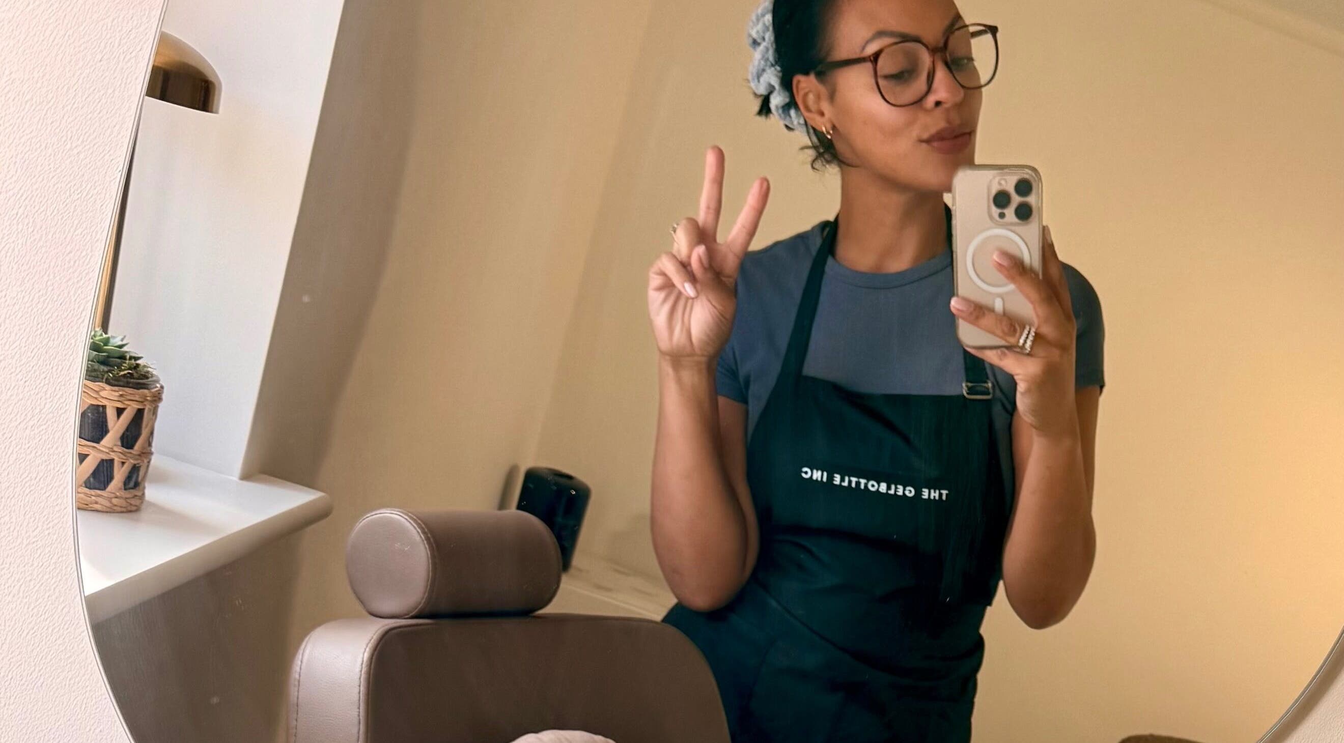 A stylist at By Carmen Rosa in Broughton Astley, England, GB, taking a mirror selfie while holding a peace sign.