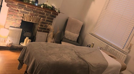 Relaxing massage room at Hollie’s Beauty Room, Eastbourne, England with rustic decor and warm lighting.