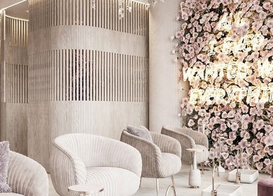Elegant waiting area at iBrows by Farah, Coventry featuring floral wall and plush seating in a modern design.