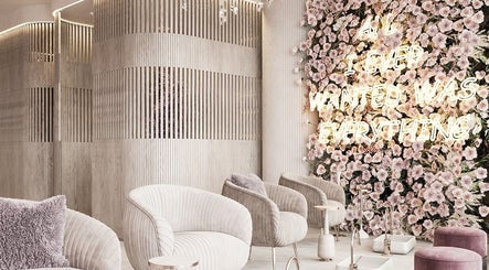 Elegant waiting area at iBrows by Farah, Coventry featuring floral wall and plush seating in a modern design.