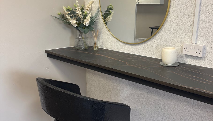 Sophisticated vanity area at Glossy Lox, Hull, England, GB featuring floral decor and a sleek mirror.